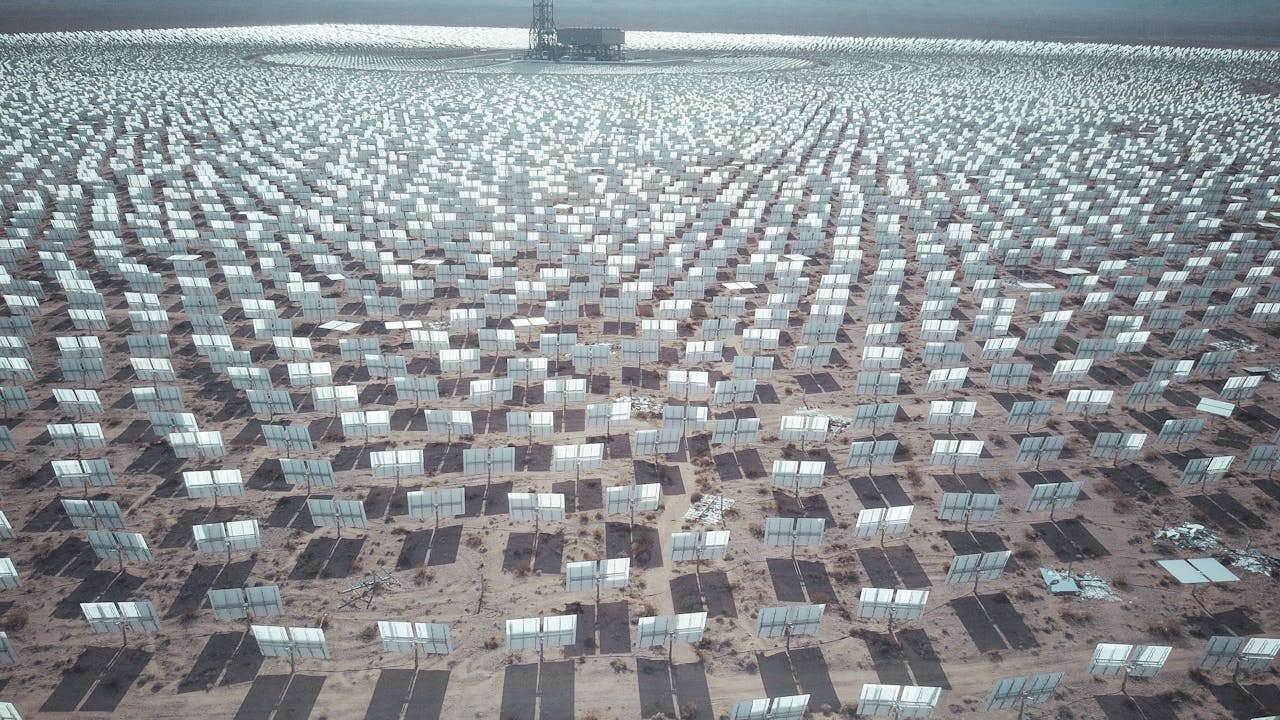 gallery-02 Aerial view of expansive solar panel array in a desert landscape generating renewable energy.