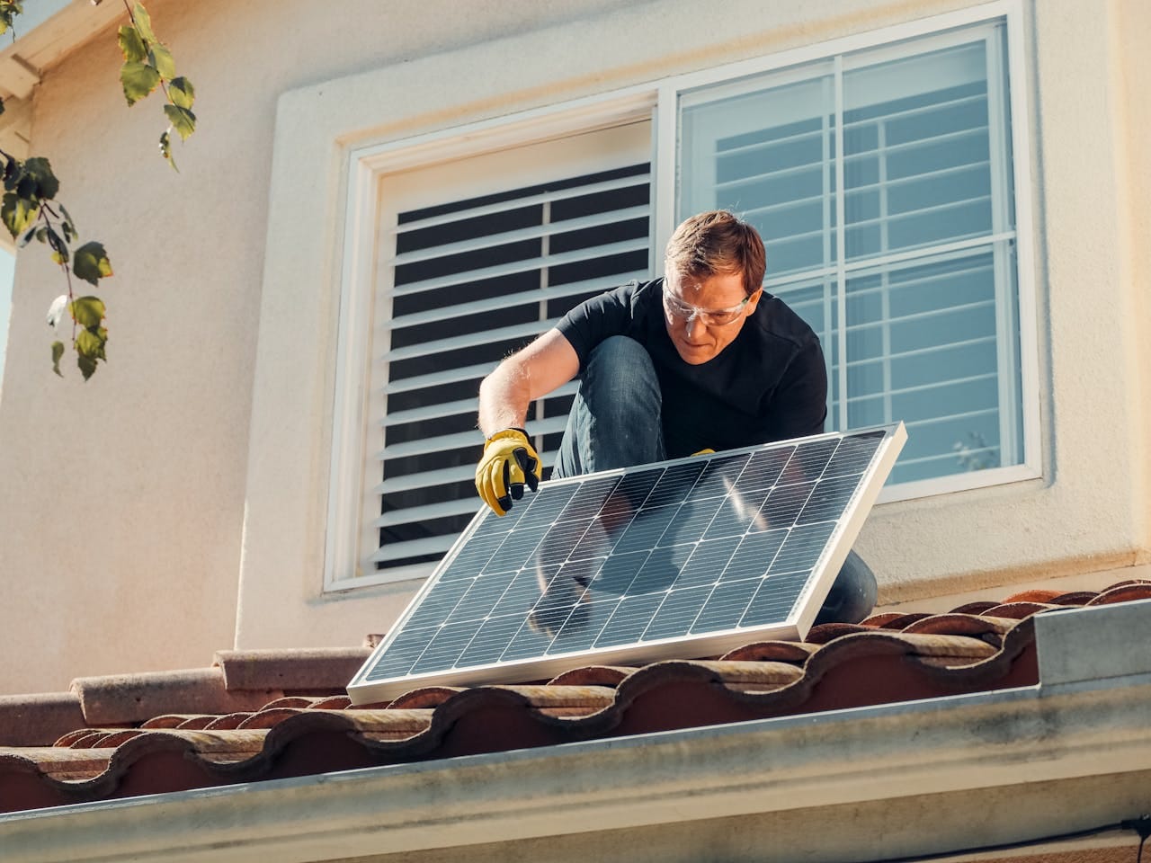 our-story Solar technician installing a photovoltaic panel on a rooftop, promoting renewable energy.